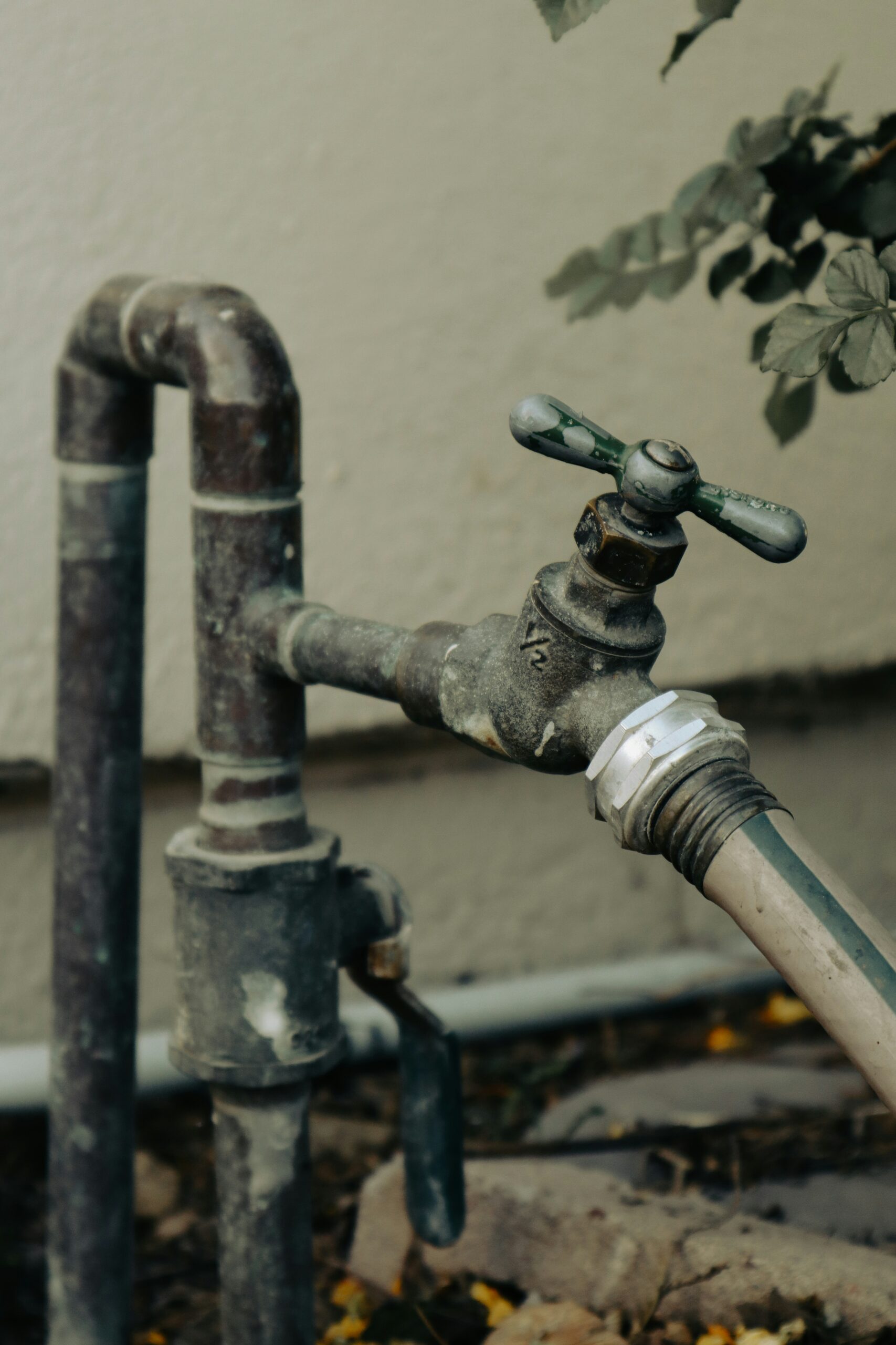 old outdoor water pipes and faucet with connected hose