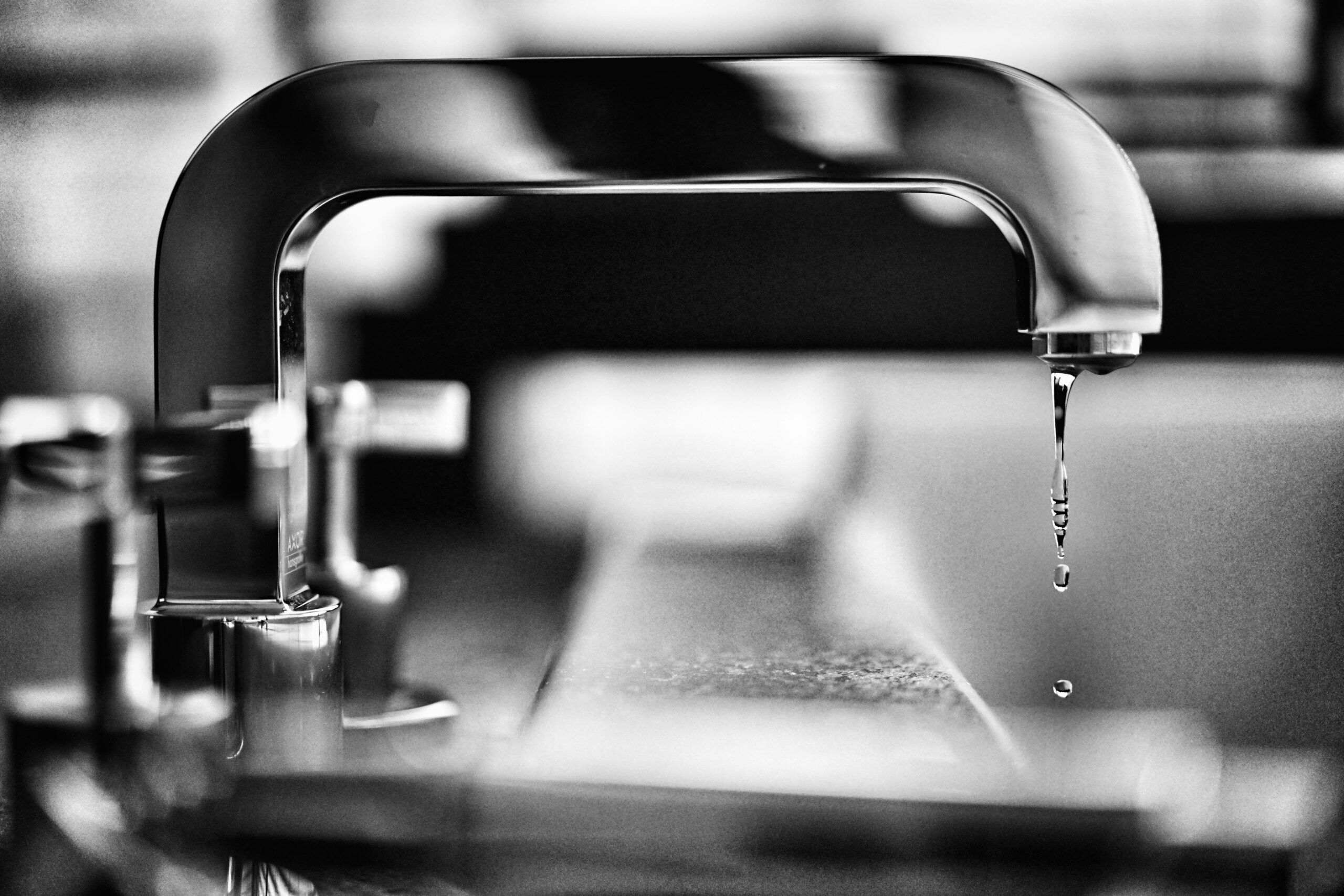 black and white photo of faucet with water dripping